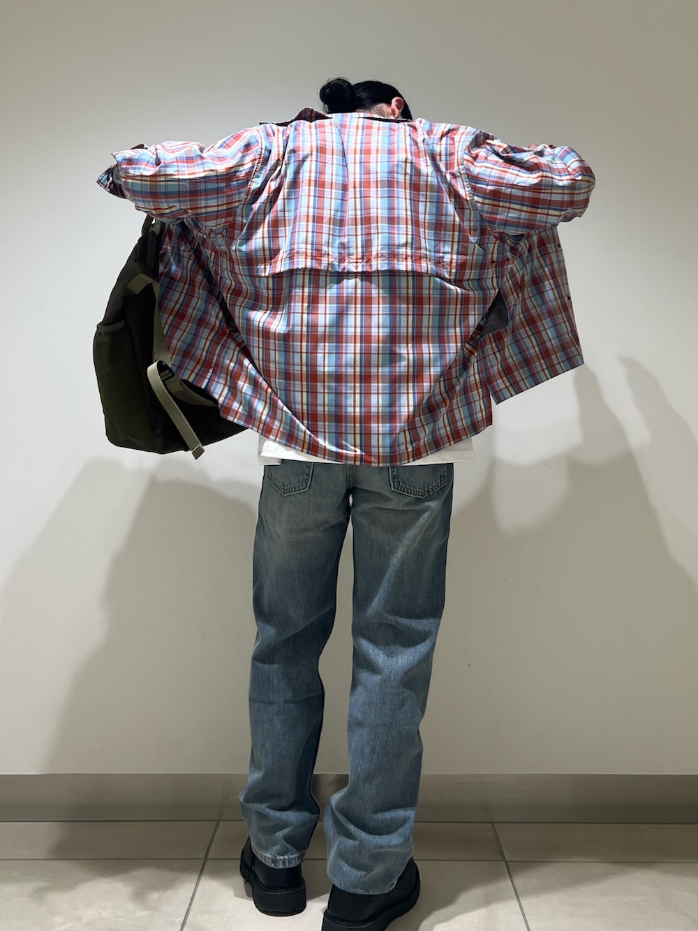 ホワイト系のTシャツ/カットソー、レッド系のシャツ/ブラウス、ブルー系のデニムパンツを着用したメンズの春コーディネートの5枚目の写真