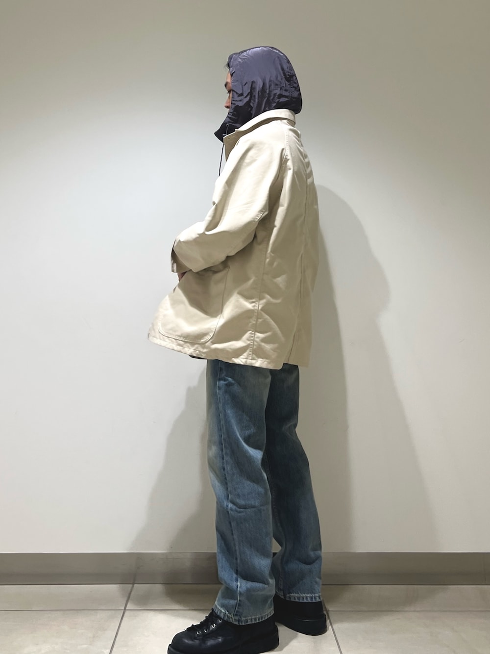 グレー系のパーカー、ホワイト系のカバーオール、ブルー系のデニムパンツを着用したメンズの冬コーディネートの5枚目の写真