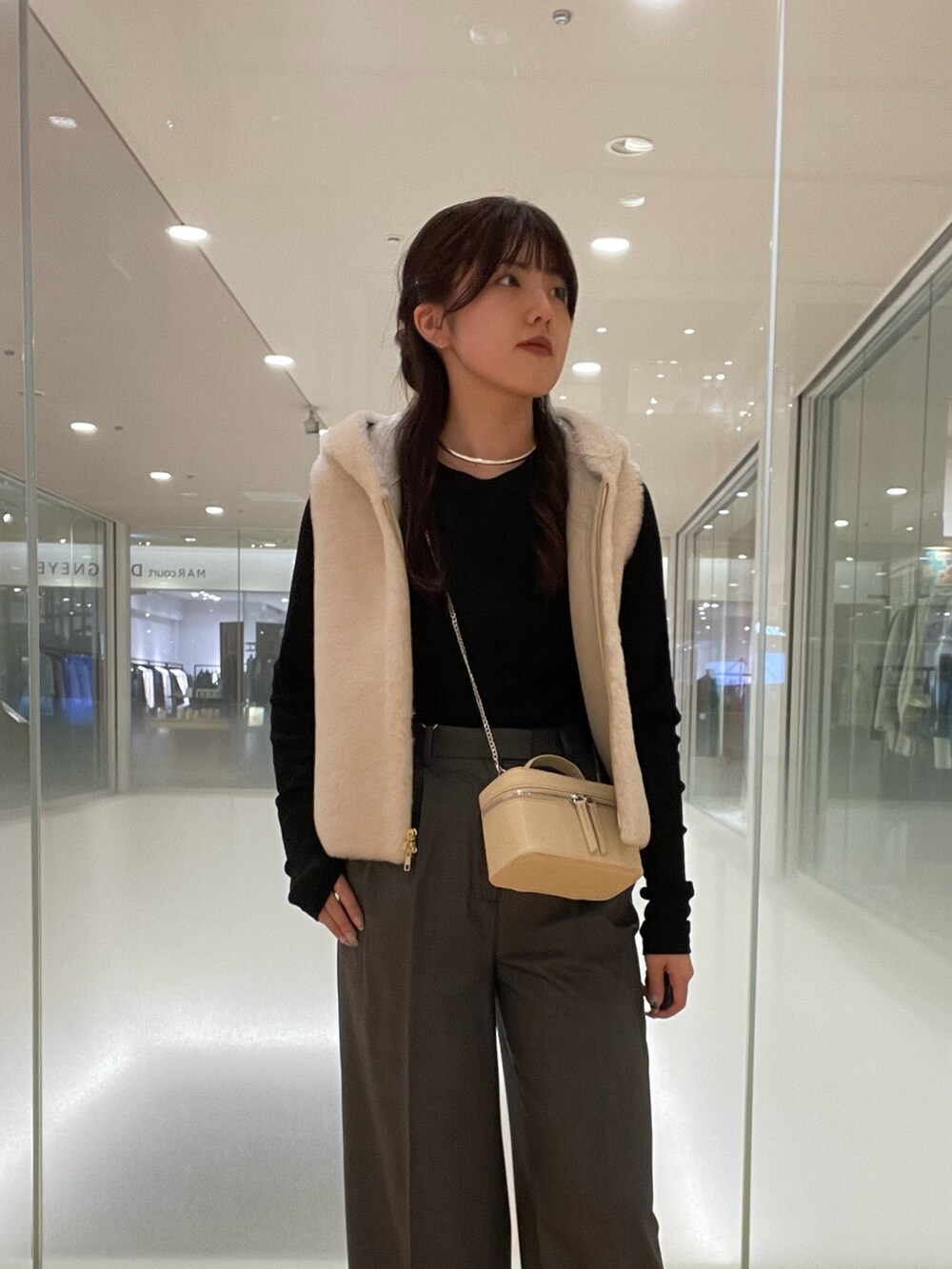 ブラック系のTシャツ/カットソー、ホワイト系のベスト、グレー系のスラックスを着用したレディースの秋コーディネートの4枚目の写真