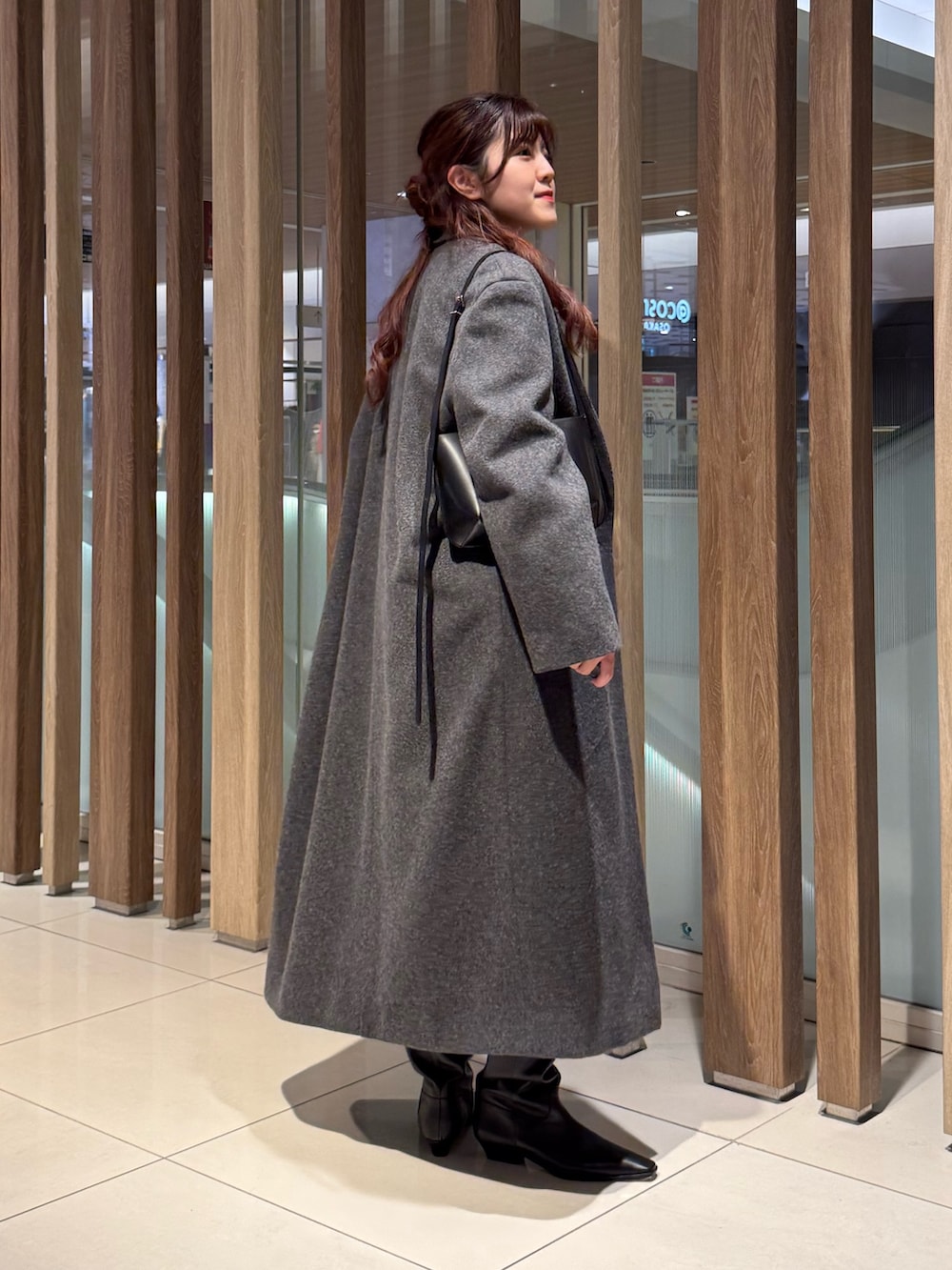 グレー系のニット/セーター、グレー系のチェスターコート、ブラック系のその他パンツを着用したレディースの冬コーディネートの4枚目の写真