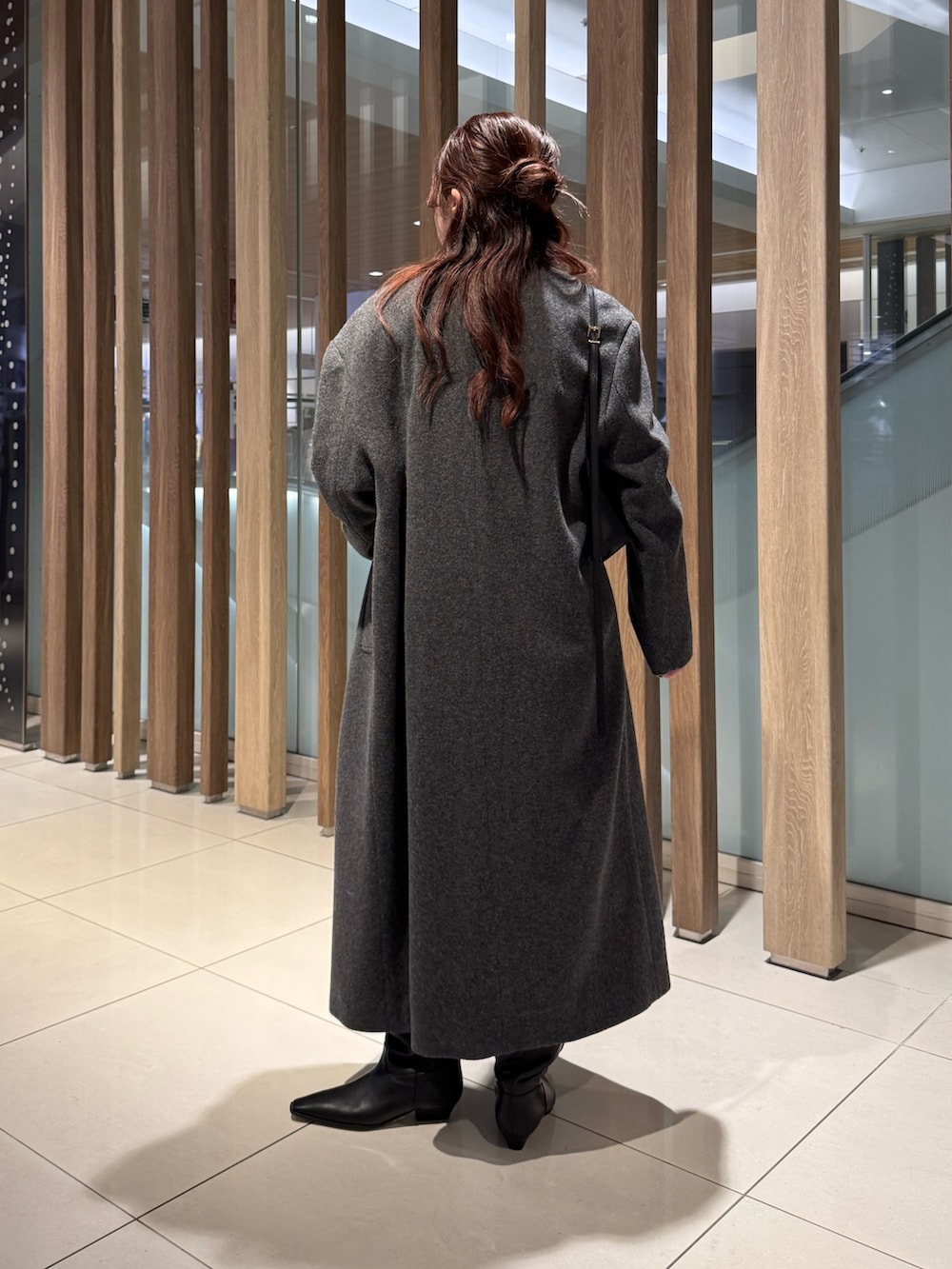 グレー系のニット/セーター、グレー系のチェスターコート、ブラック系のその他パンツを着用したレディースの冬コーディネートの2枚目の写真