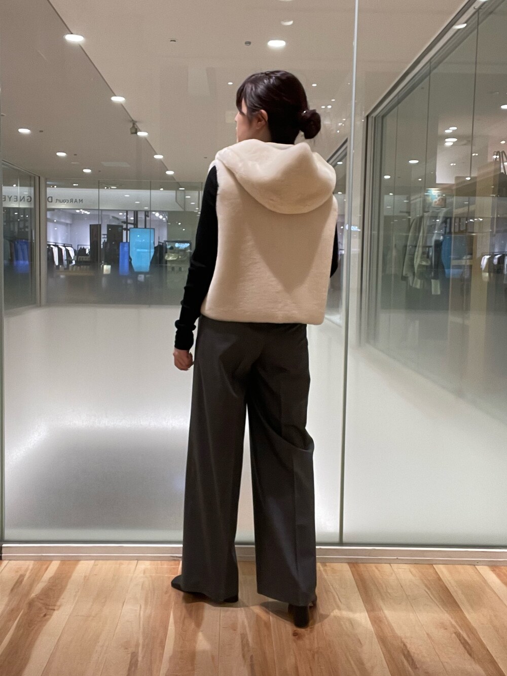 ブラック系のTシャツ/カットソー、ホワイト系のベスト、グレー系のスラックスを着用したレディースの秋コーディネートの3枚目の写真