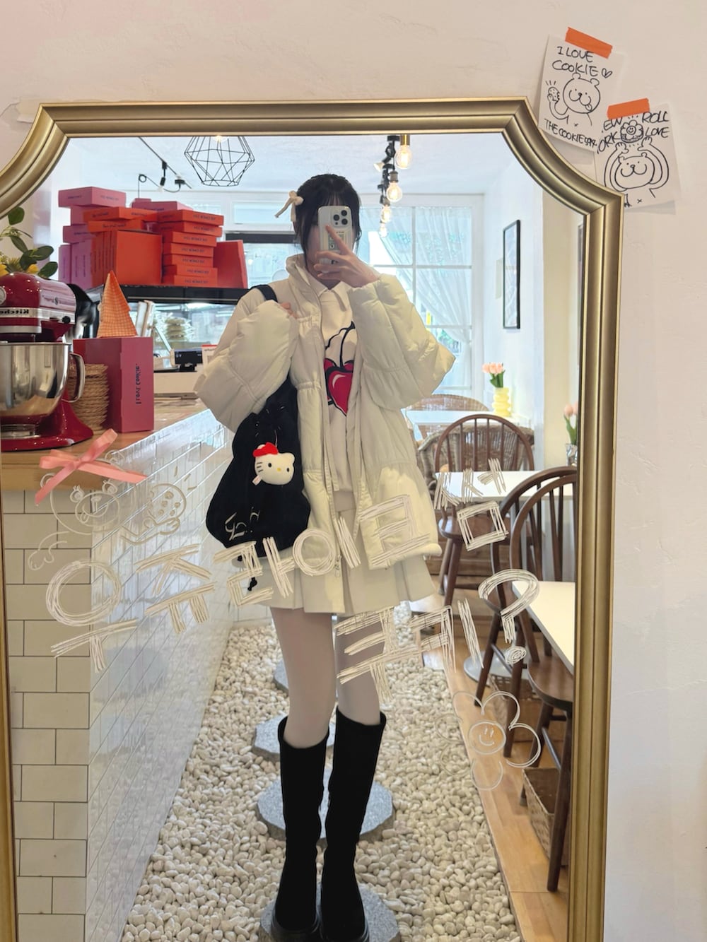 ブラック系のブーツ、ホワイト系のその他アウター、ホワイト系のスカートを着用したレディースの冬コーディネートの3枚目の写真