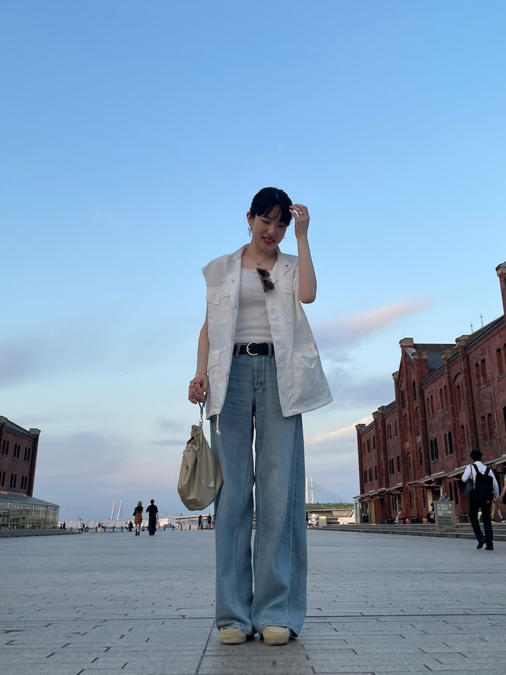 ベージュ系のその他シューズ、ブルー系のデニムパンツ、ホワイト系のベストを着用したレディースの夏コーディネートの2枚目の写真