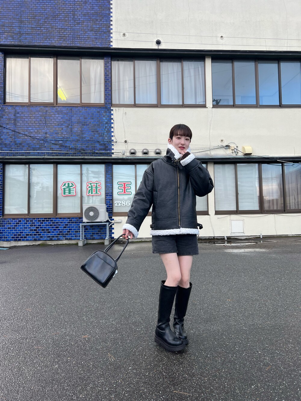 ブラック系のブーツ、ブラック系のブルゾン、ブラック系のハンドバッグを着用したレディースの冬コーディネートの2枚目の写真