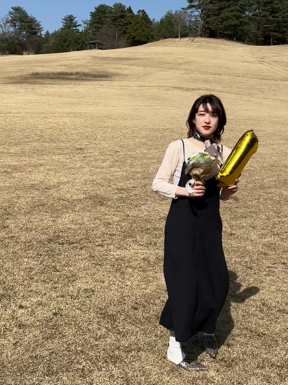 ブラック系のワンピース、その他のその他シューズ、ブラウン系のストール/ショールを着用したレディースの春コーディネートの2枚目の写真