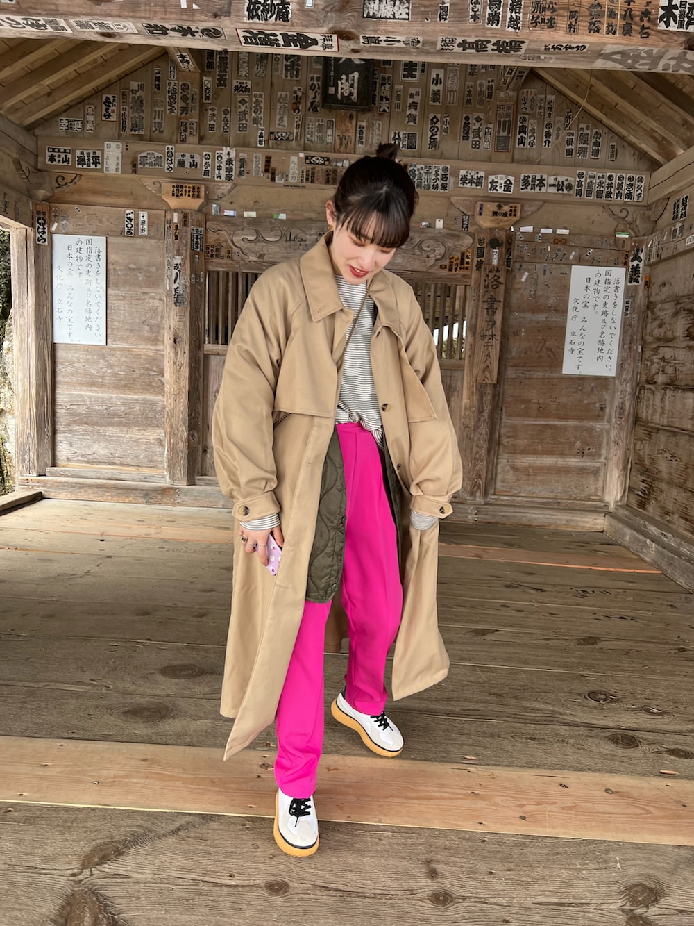 ベージュ系のトレンチコート、ピンク系のスラックス、ホワイト系のTシャツ/カットソーを着用したレディースの春コーディネートの2枚目の写真