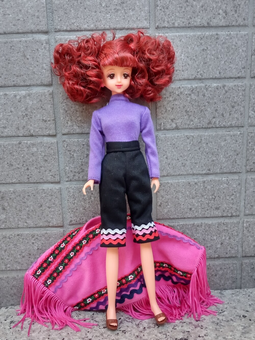 ブラウン系のサンダル、ピンク系のポンチョを着用したレディースの秋コーディネートの3枚目の写真