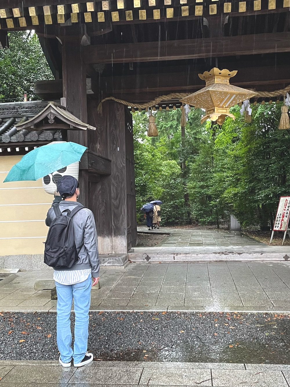 ブラック系のスニーカー、ブルー系のデニムパンツ、グレー系のブルゾンを着用したメンズの秋コーディネートの5枚目の写真