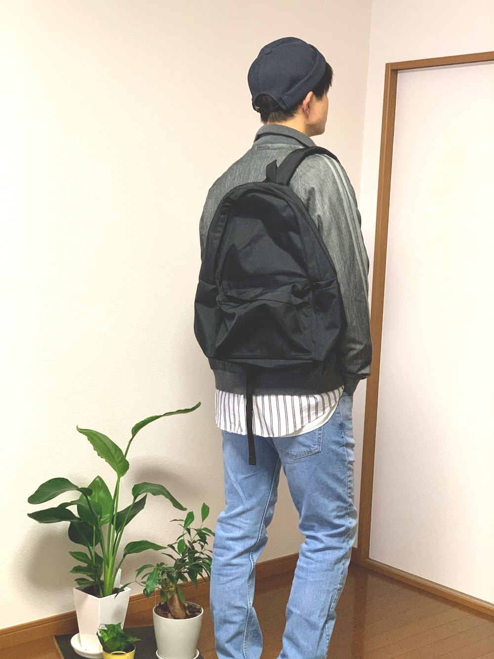 ブラック系のスニーカー、ブルー系のデニムパンツ、グレー系のブルゾンを着用したメンズの秋コーディネートの2枚目の写真