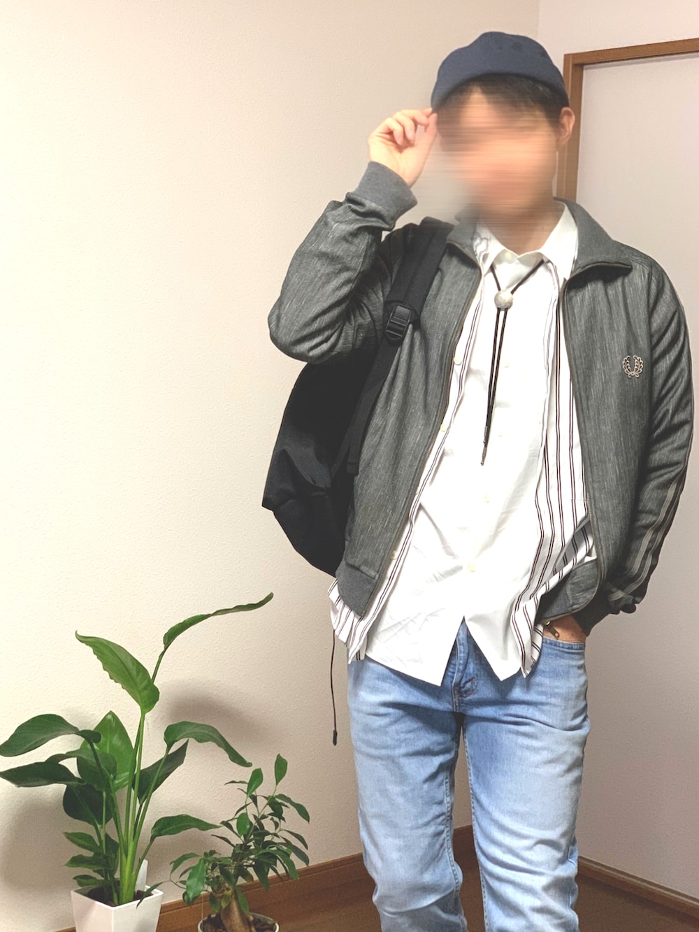 ブラック系のスニーカー、ブルー系のデニムパンツ、グレー系のブルゾンを着用したメンズの秋コーディネートの3枚目の写真