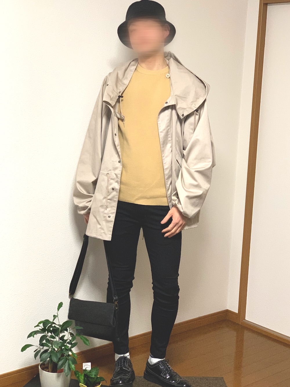 ブラック系のドレスシューズ、ブラック系のクラッチバッグ、ブラック系のデニムパンツを着用したメンズの春コーディネートの3枚目の写真