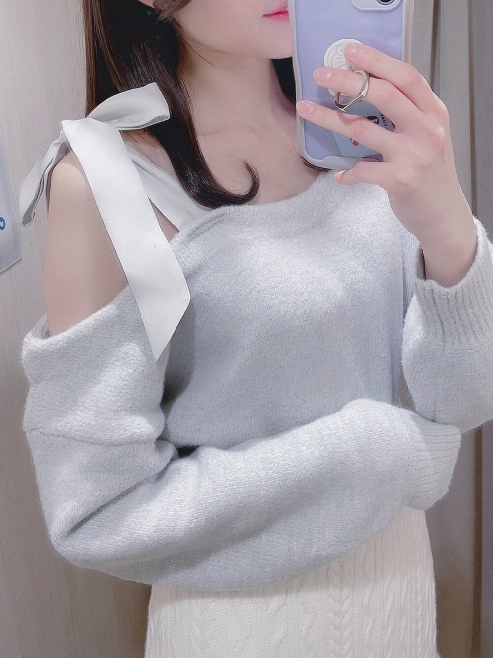 グレー系のニット/セーター、ホワイト系のスカートを着用したレディースの冬コーディネートの2枚目の写真