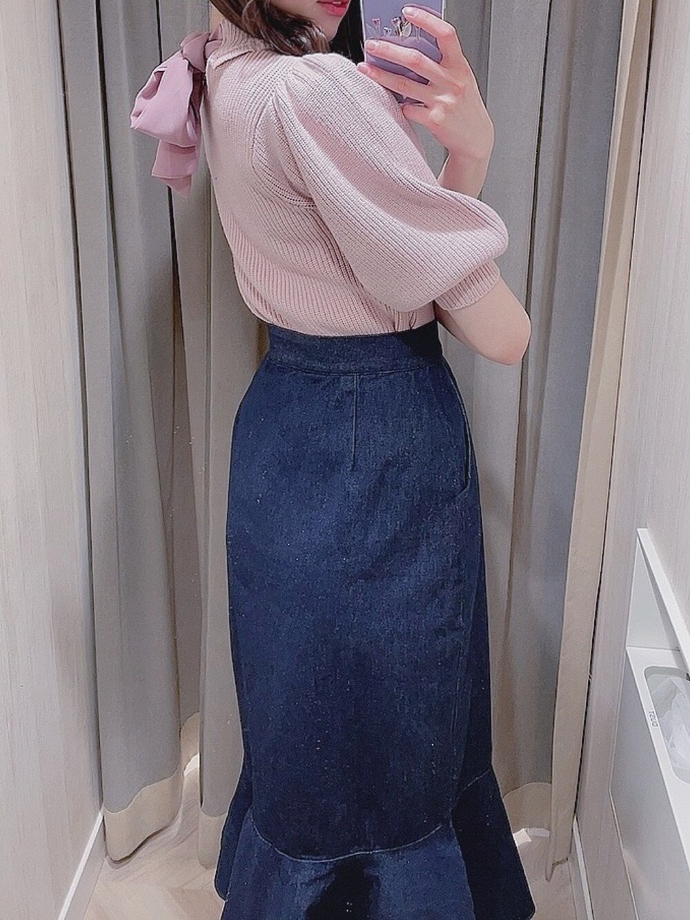 ピンク系のニット/セーター、ブルー系のスカートを着用したレディースの冬コーディネートの2枚目の写真