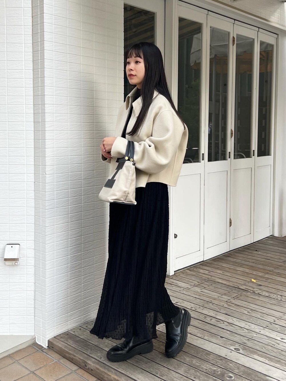 ブラック系のトートバッグ、ベージュ系のブルゾン、ブラック系のスカートを着用したレディースの冬コーディネートの3枚目の写真