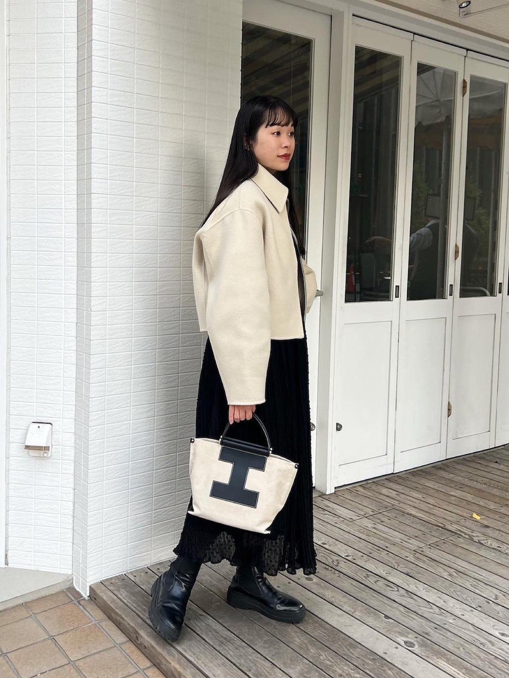 ブラック系のトートバッグ、ベージュ系のブルゾン、ブラック系のスカートを着用したレディースの冬コーディネートの2枚目の写真