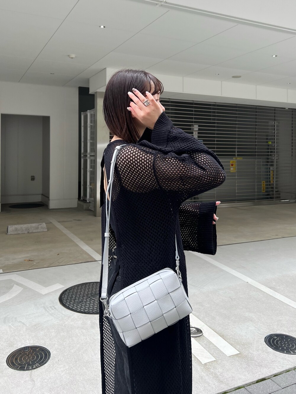 グレー系のショルダーバッグ、ブラック系のサンダルを着用したレディースの春コーディネートの2枚目の写真