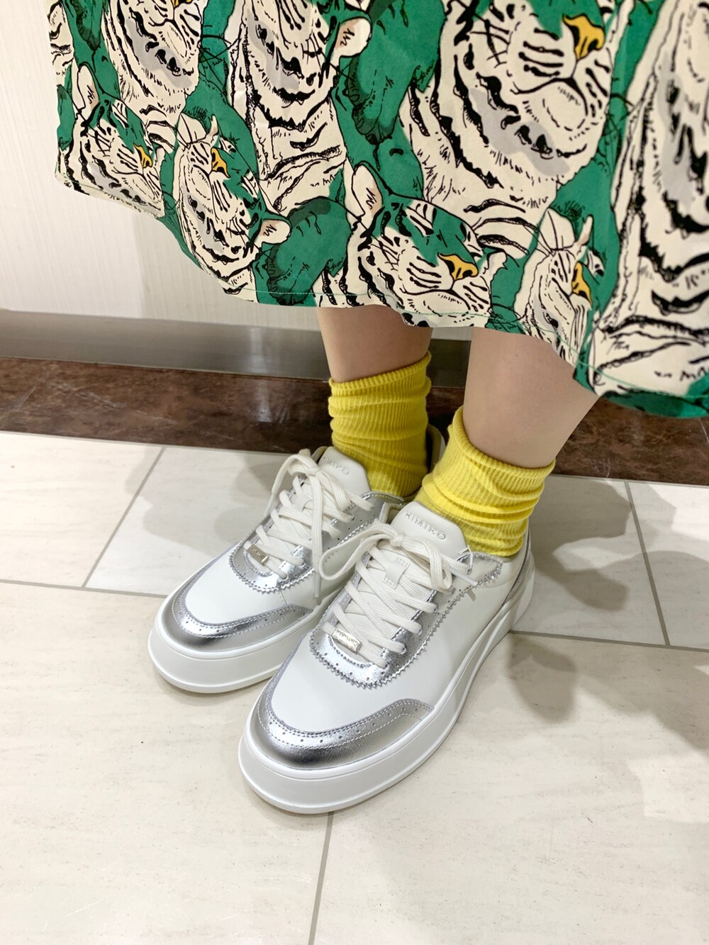 シルバー系のスニーカーを着用したレディースの春コーディネートの2枚目の写真