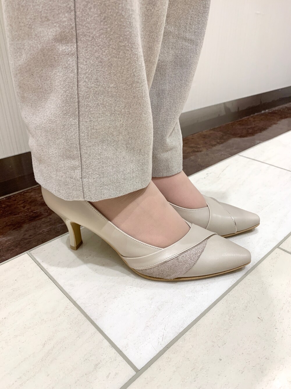 ホワイト系のパンプスを着用したレディースの春コーディネートの2枚目の写真