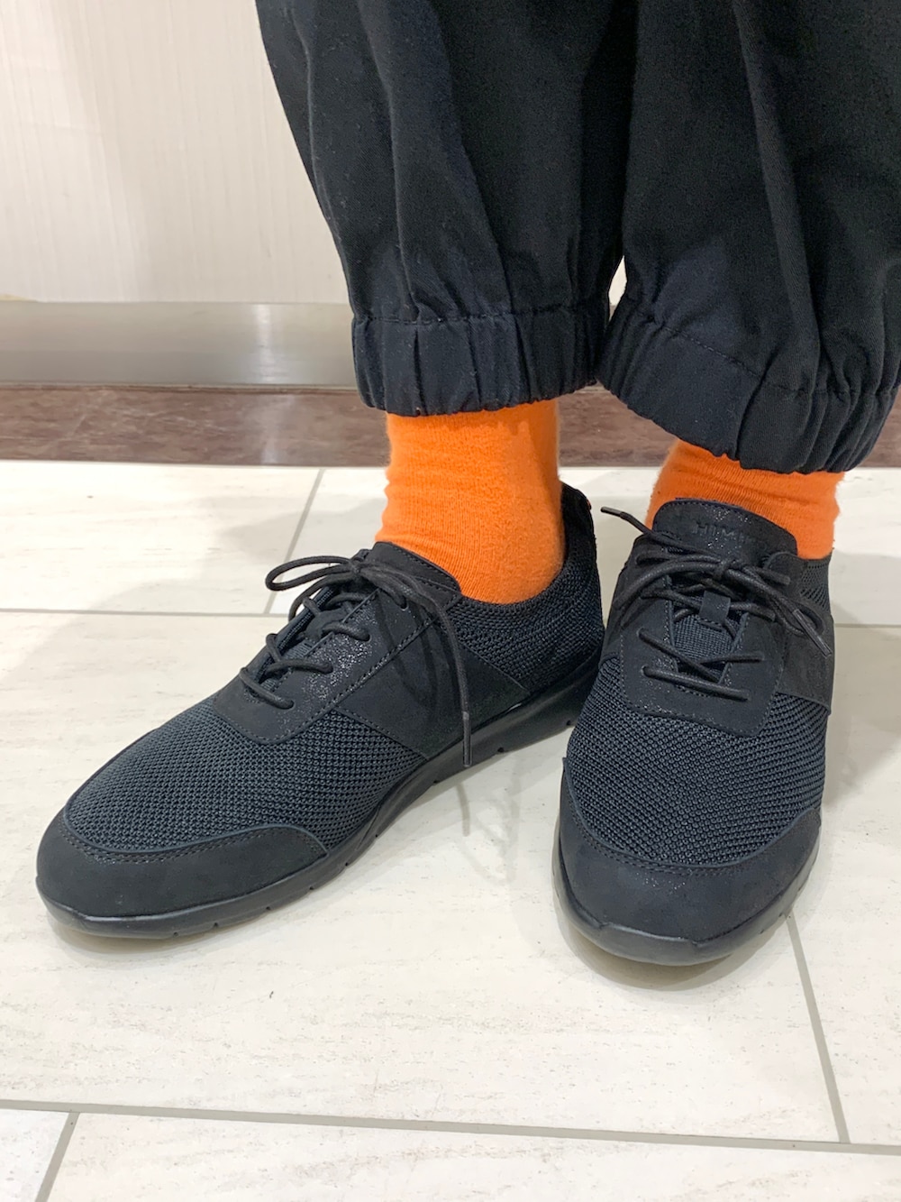 ブラック系のスニーカーを着用したレディースの秋コーディネートの2枚目の写真