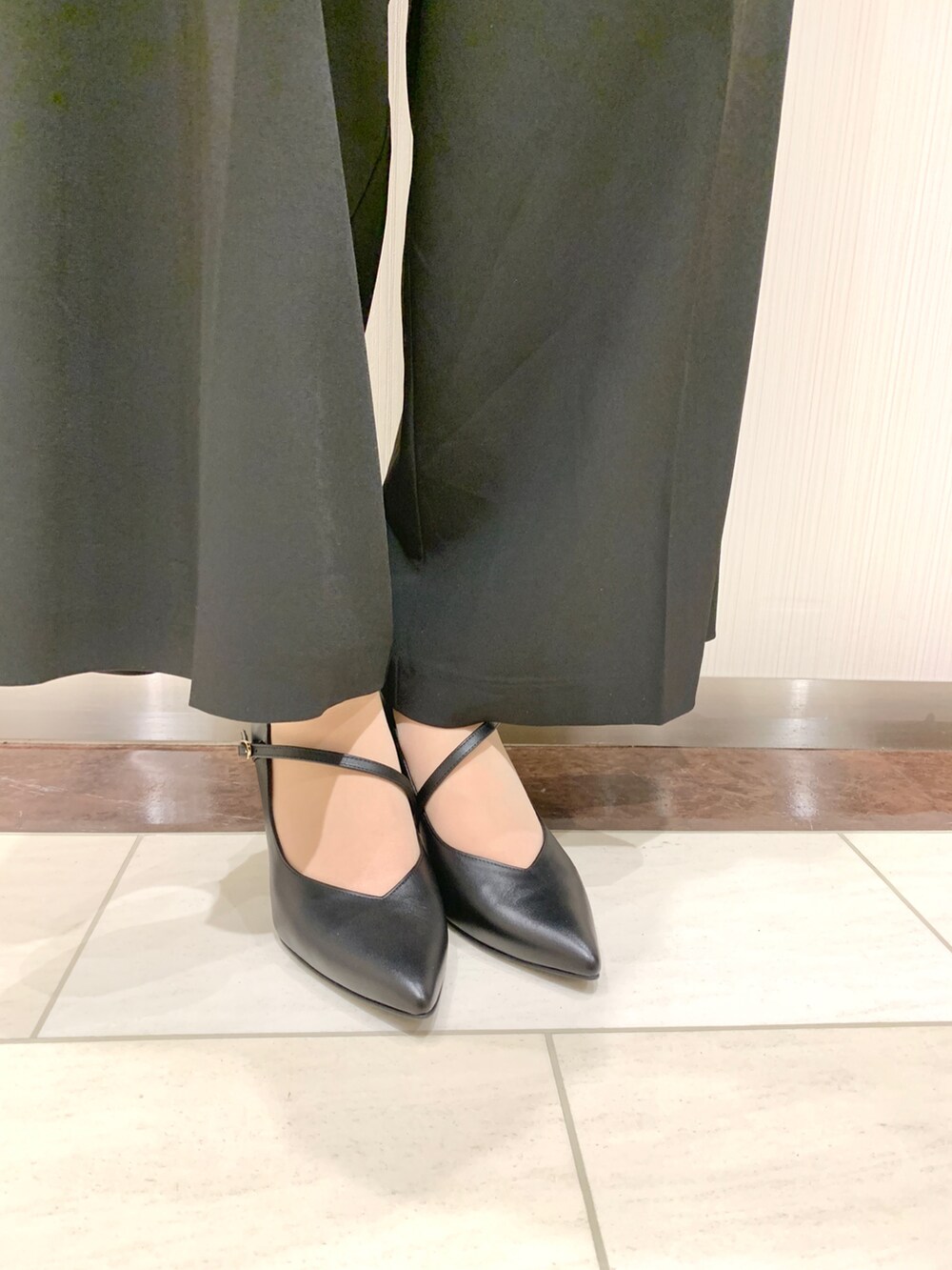 ブラック系のパンプスを着用したレディースの春コーディネートの2枚目の写真