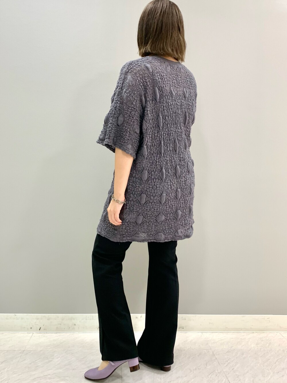 パープル系のパンプスを着用したレディースの夏コーディネートの2枚目の写真