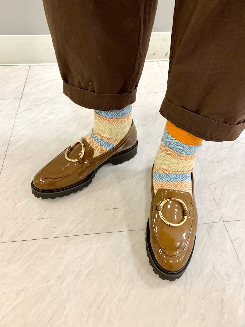 ブラウン系のローファーを着用したレディースの秋コーディネートの2枚目の写真