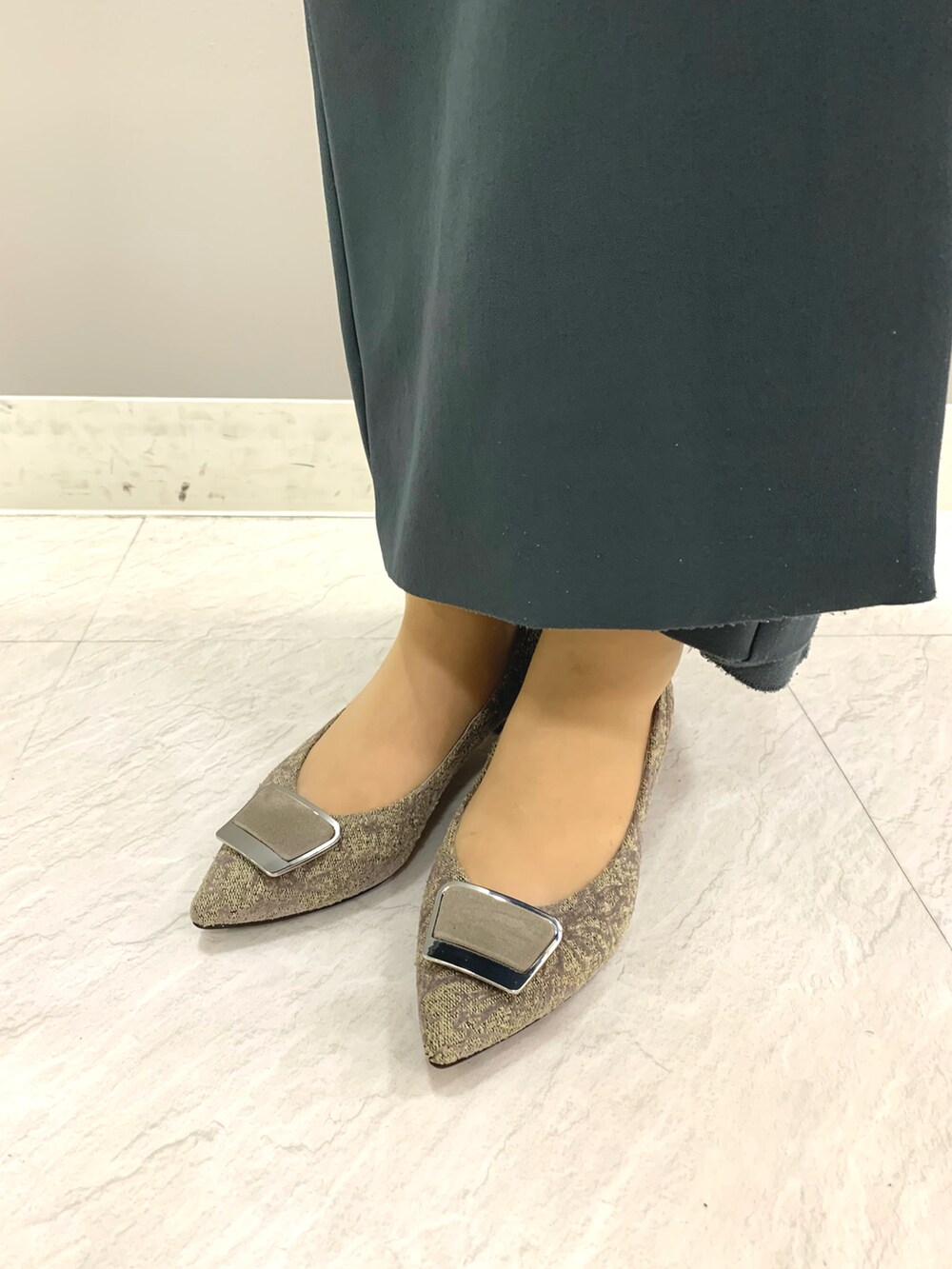 グレー系のパンプスを着用したレディースの夏コーディネートの2枚目の写真