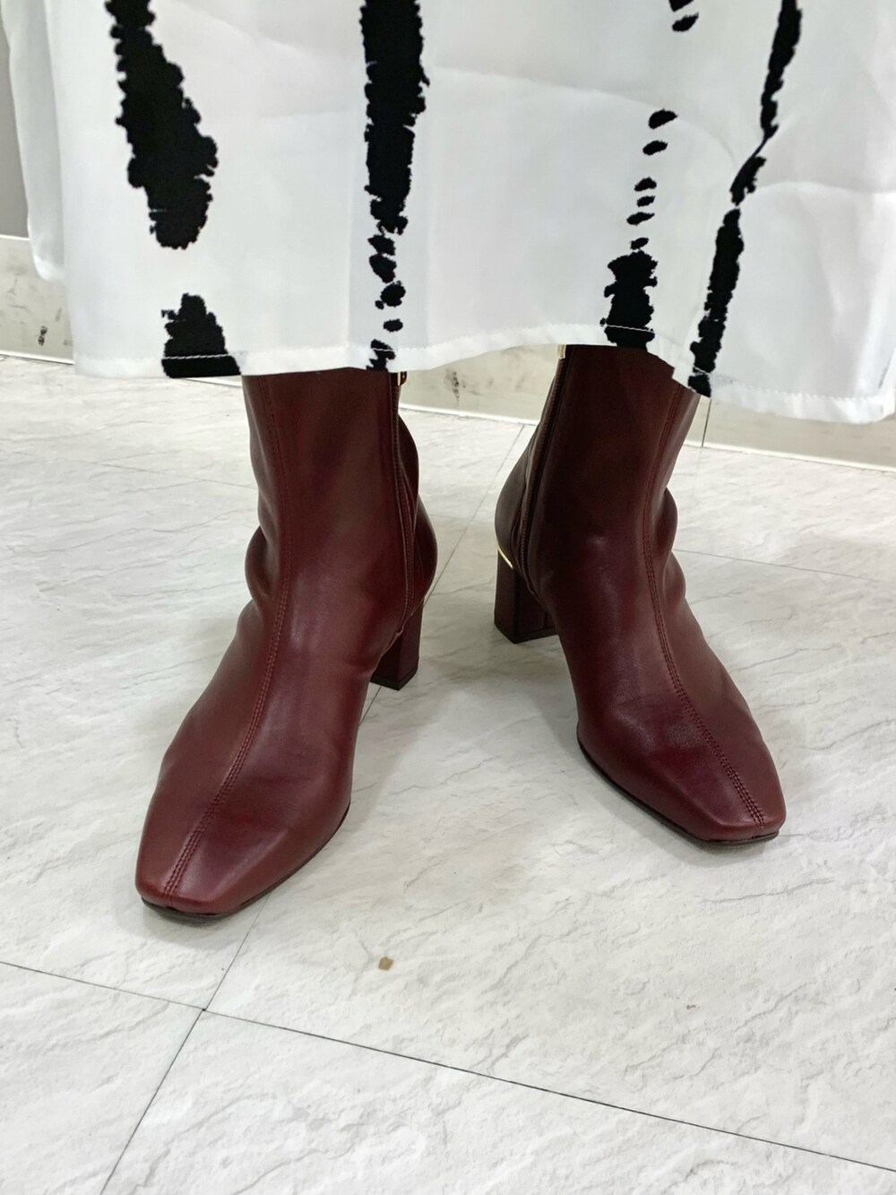 レッド系のブーツを着用したレディースの秋コーディネートの2枚目の写真