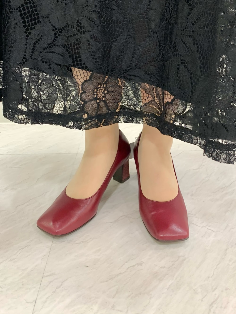 レッド系のパンプスを着用したレディースの夏コーディネートの2枚目の写真