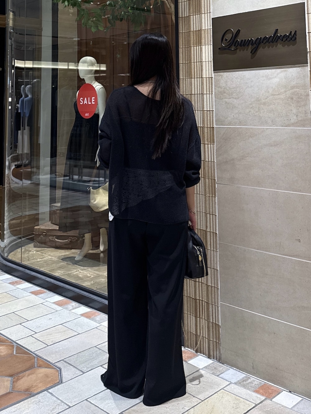 ブラック系のニット/セーター、ブラック系のその他パンツ、シルバー系のサンダルを着用したレディースの夏コーディネートの2枚目の写真