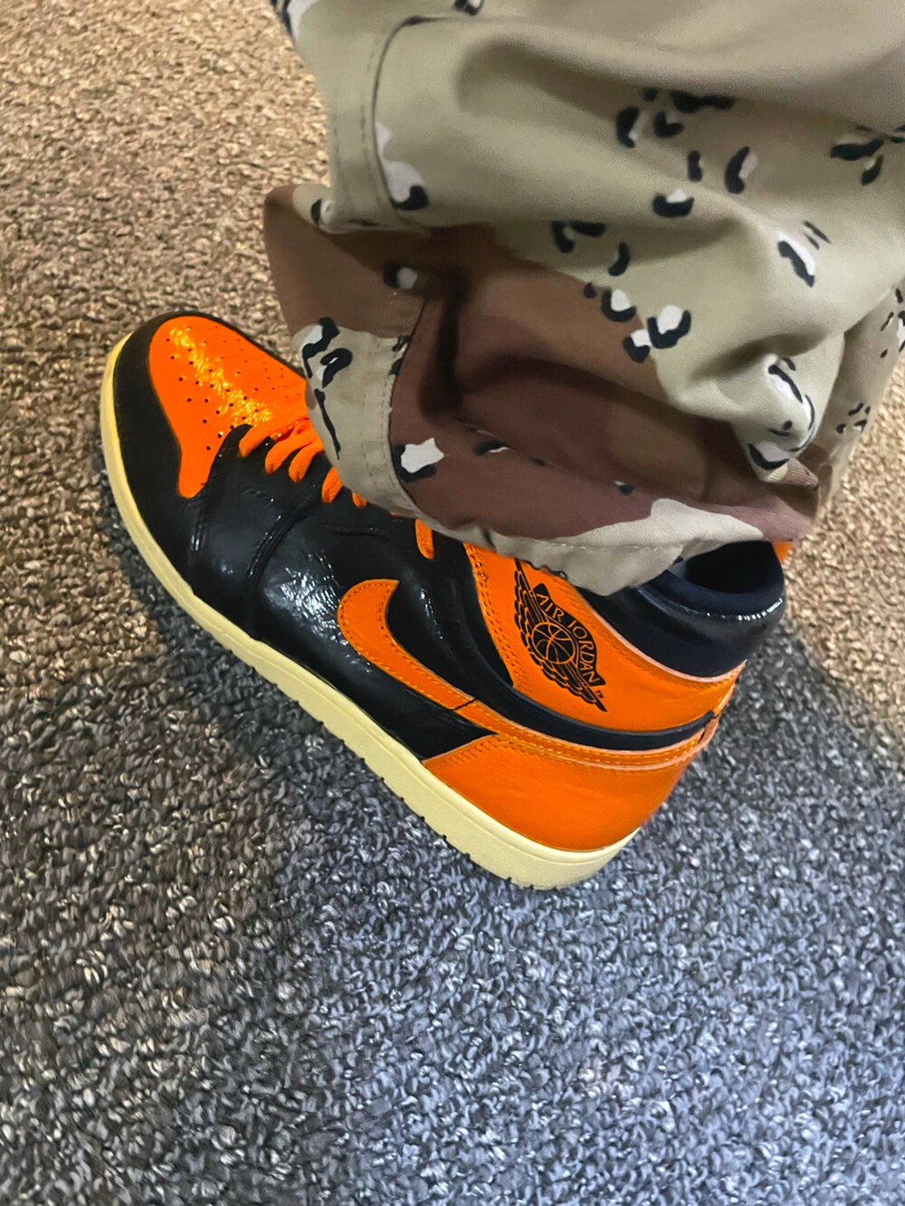 ブラック系のTシャツ/カットソー、オレンジ系のスニーカー、ブラック系のニットキャップ/ビーニーを着用したメンズの秋コーディネートの4枚目の写真