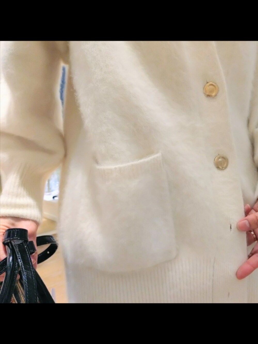 ホワイト系のカーディガン/ボレロ、ホワイト系のスカート、ブラウン系のバッグを着用したレディースの冬コーディネートの5枚目の写真