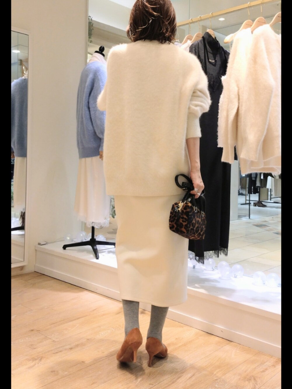 ホワイト系のカーディガン/ボレロ、ホワイト系のスカート、ブラウン系のバッグを着用したレディースの冬コーディネートの3枚目の写真