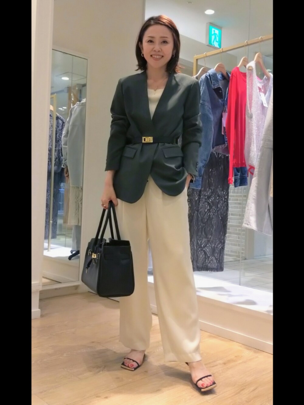 グレー系のノーカラージャケット、ホワイト系のニット/セーター、ブラック系のトートバッグを着用したレディースの秋コーディネートの5枚目の写真