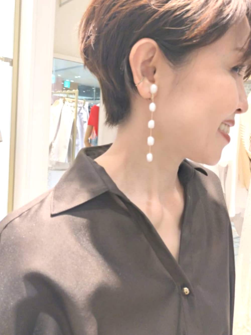ブラウン系のシャツ/ブラウス、ホワイト系のスカート、ブラック系のトートバッグを着用したレディースの夏コーディネートの6枚目の写真