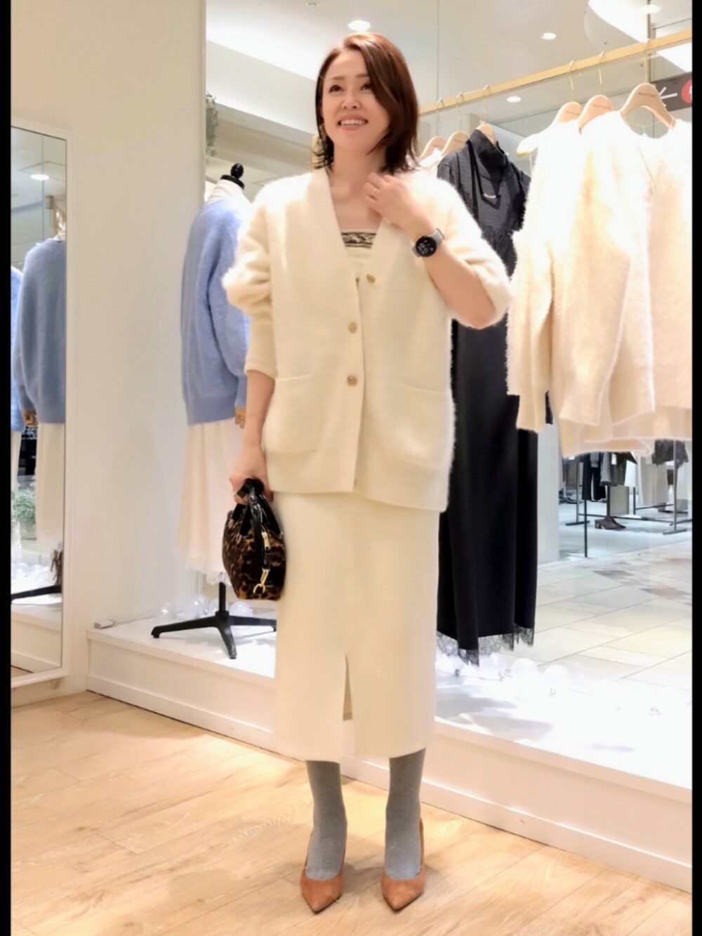 ホワイト系のカーディガン/ボレロ、ホワイト系のスカート、ブラウン系のバッグを着用したレディースの冬コーディネートの4枚目の写真