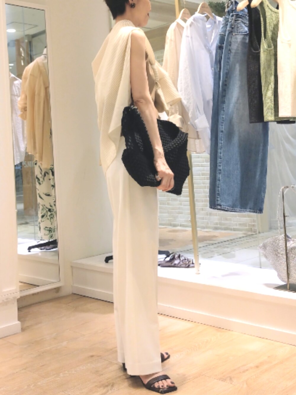 グリーン系のニット/セーター、ベージュ系のシャツ/ブラウス、ホワイト系のその他パンツを着用したレディースの夏コーディネートの6枚目の写真