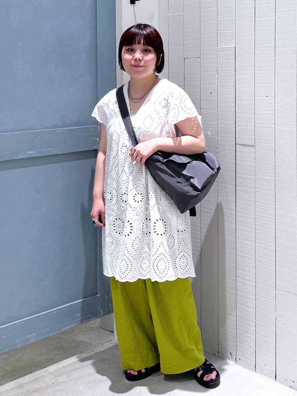 ホワイト系のワンピース、ブラック系のスニーカー、グリーン系のスラックスを着用したレディースの夏コーディネートの2枚目の写真