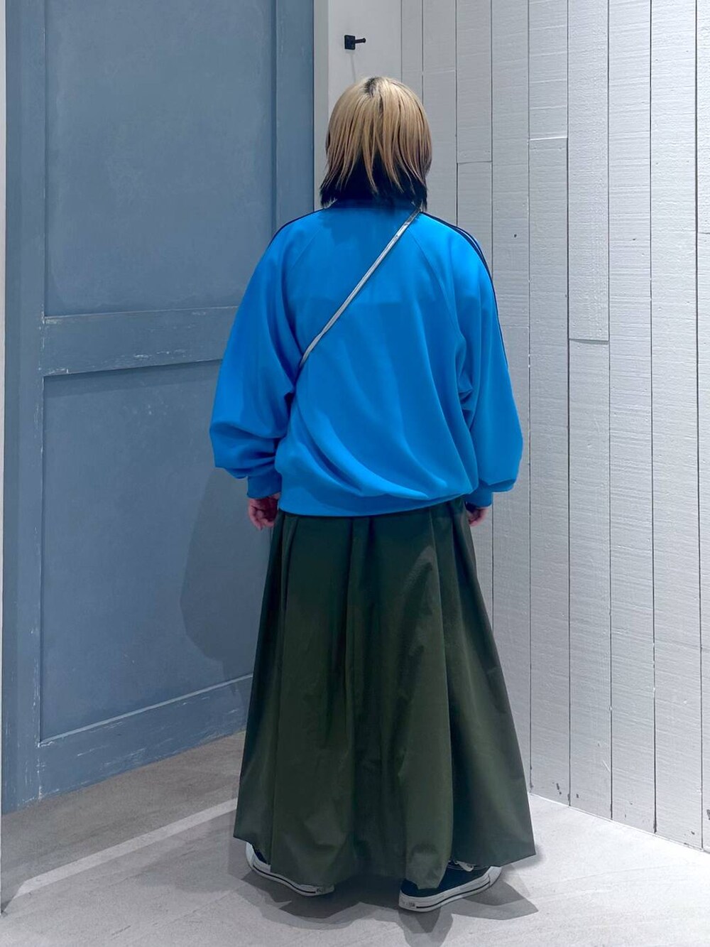 シルバー系のハンドバッグ、グリーン系のワンピース、ブルー系のTシャツ/カットソーを着用したレディースの秋コーディネートの5枚目の写真