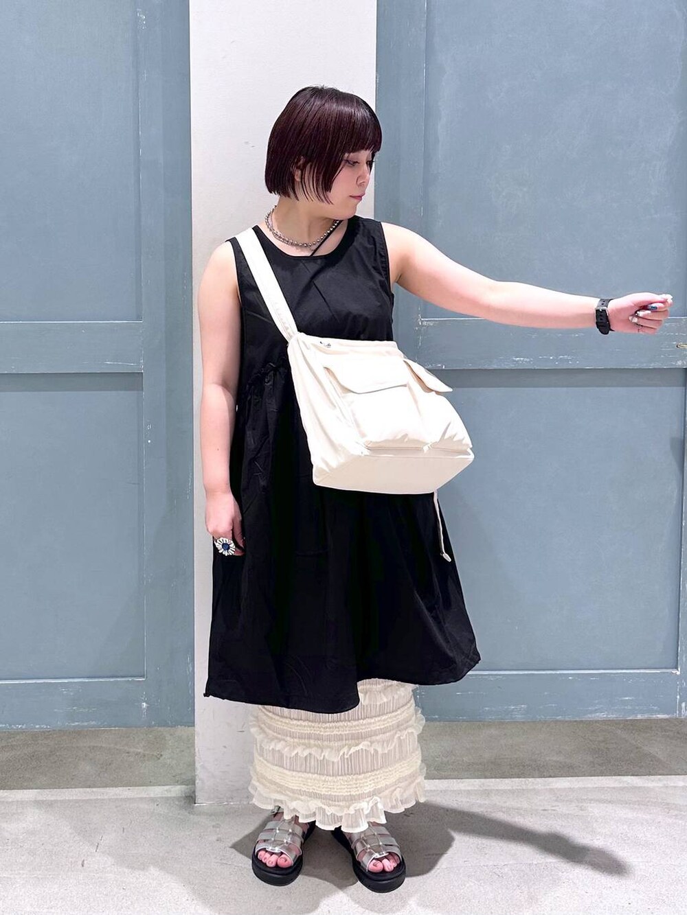 ブラック系のTシャツ/カットソー、ホワイト系のスカート、シルバー系のスニーカーを着用したレディースの夏コーディネートの5枚目の写真