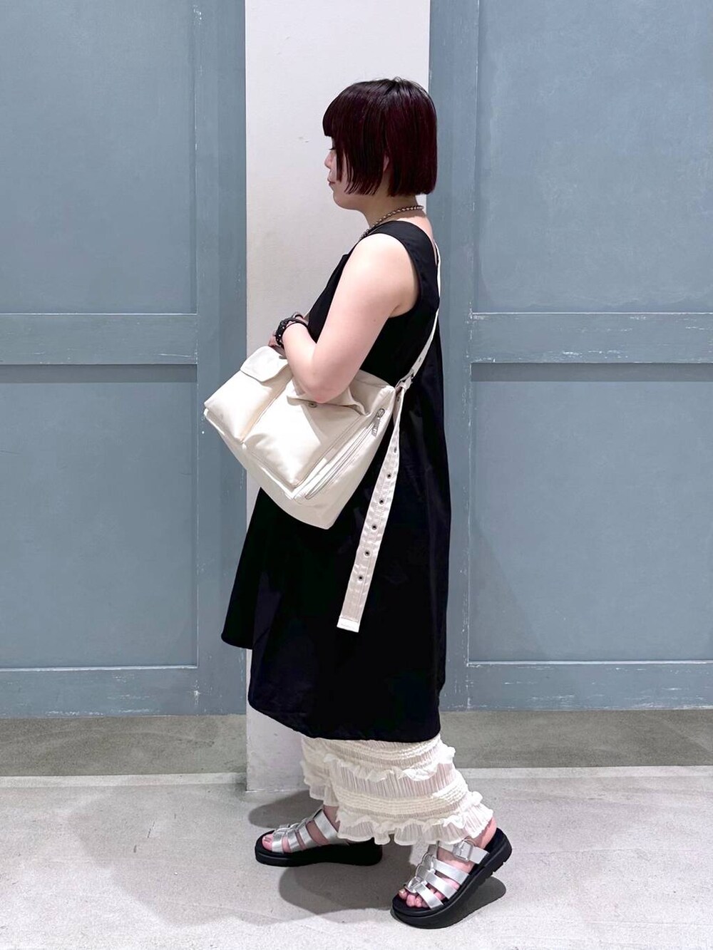 ブラック系のTシャツ/カットソー、ホワイト系のスカート、シルバー系のスニーカーを着用したレディースの夏コーディネートの3枚目の写真