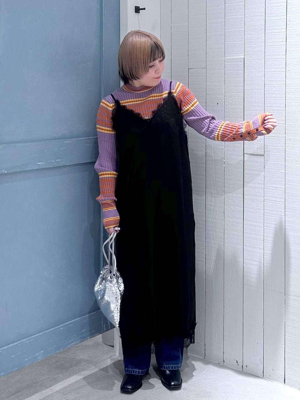 ブルー系のデニムパンツ、ブラック系のパンプス、シルバー系のハンドバッグを着用したレディースの秋コーディネートの6枚目の写真