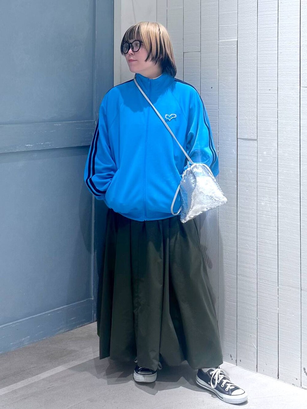 シルバー系のハンドバッグ、グリーン系のワンピース、ブルー系のTシャツ/カットソーを着用したレディースの秋コーディネートの3枚目の写真