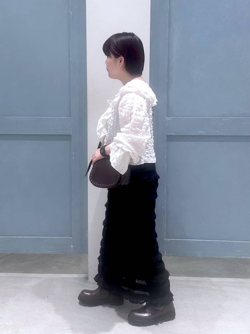 ホワイト系のシャツ/ブラウス、ブラウン系のショルダーバッグ、ブラウン系のブーツを着用したレディースの秋コーディネートの3枚目の写真