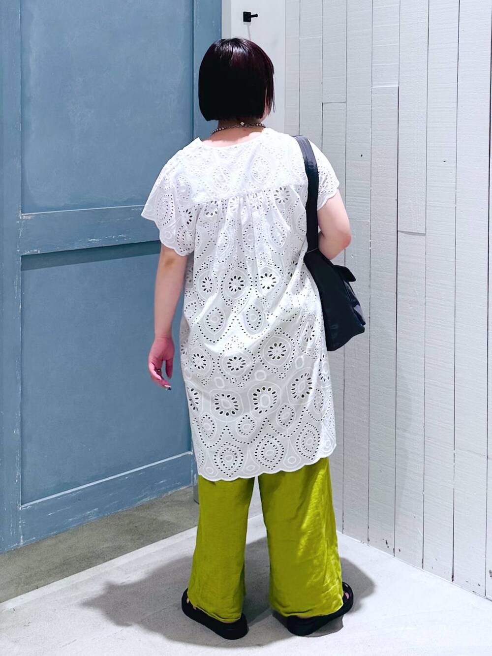 ホワイト系のワンピース、ブラック系のスニーカー、グリーン系のスラックスを着用したレディースの夏コーディネートの4枚目の写真