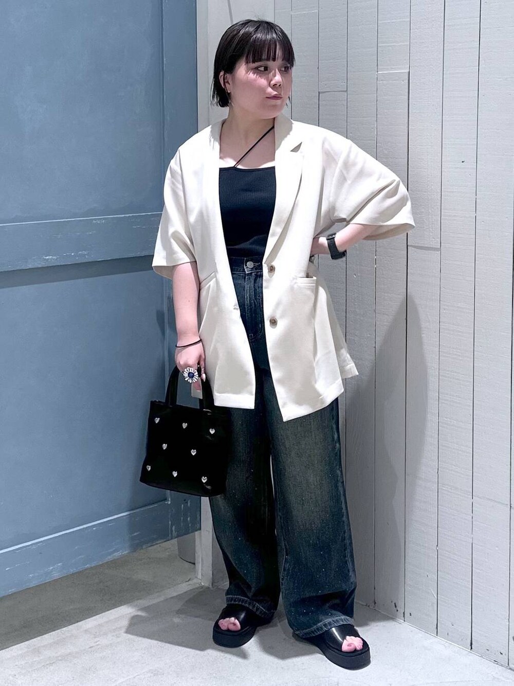 ブルー系のデニムパンツ、ブラック系のショルダーバッグ、ブラック系のサンダルを着用したレディースの夏コーディネートの2枚目の写真