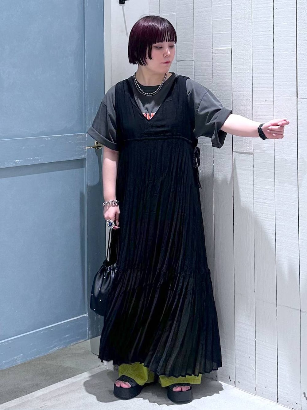 ブラック系のサンダル、ブラック系のショルダーバッグ、グリーン系のスラックスを着用したレディースの夏コーディネートの5枚目の写真