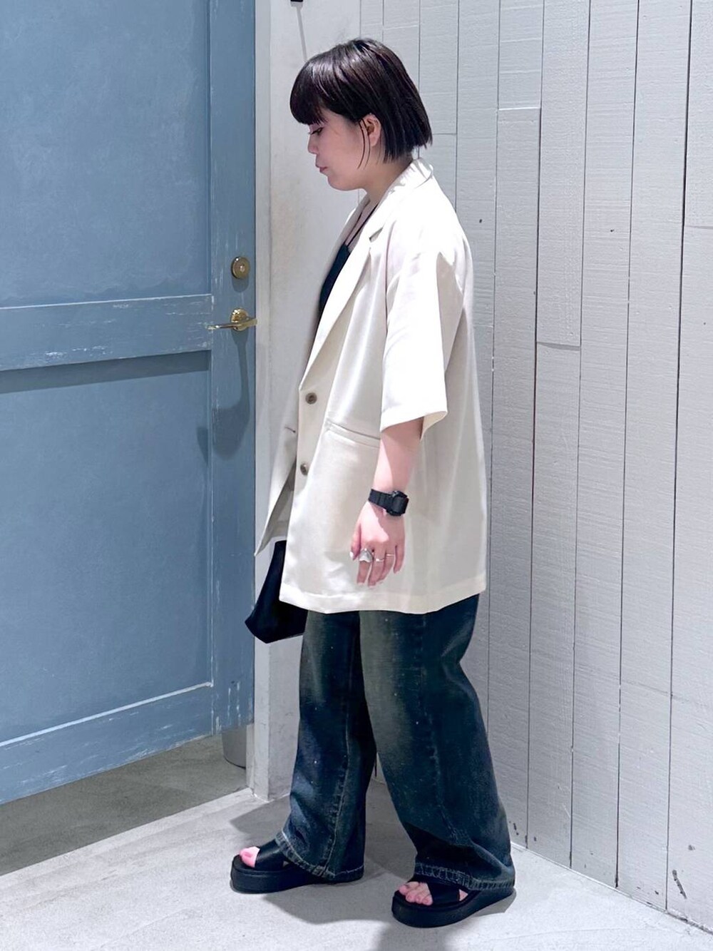 ブルー系のデニムパンツ、ブラック系のショルダーバッグ、ブラック系のサンダルを着用したレディースの夏コーディネートの3枚目の写真