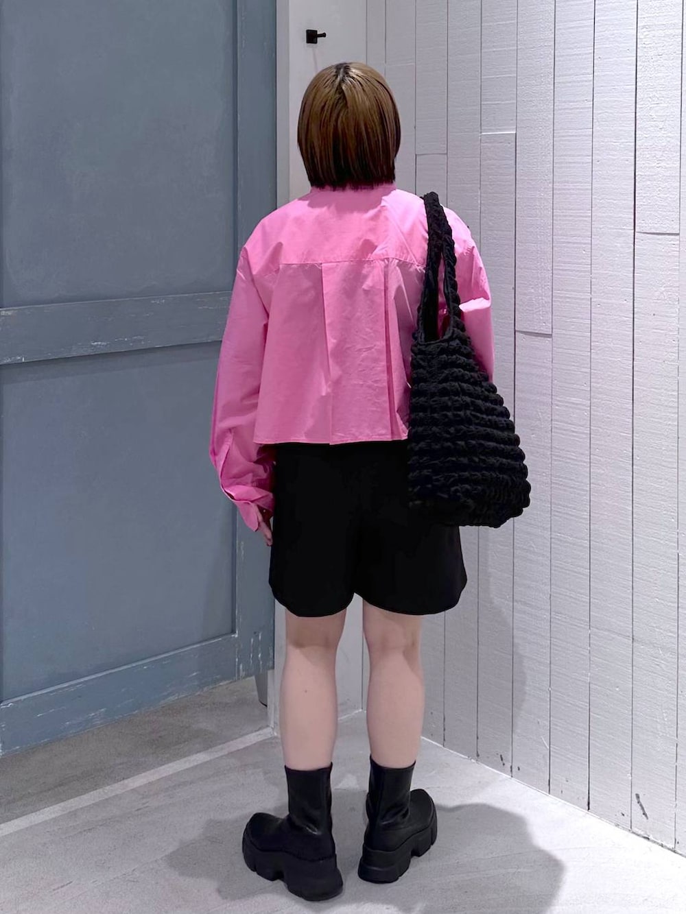 ブラック系のショルダーバッグ、ブラック系のブーツ、ピンク系のシャツ/ブラウスを着用したレディースの秋コーディネートの5枚目の写真